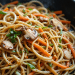 nouilles sautées chow mein dans un wok avec légumes croquants